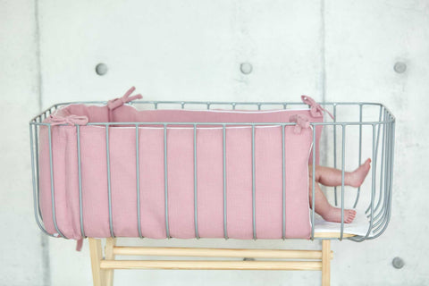 Bettumrandung aus Musselin in Rosa im Babybett.
