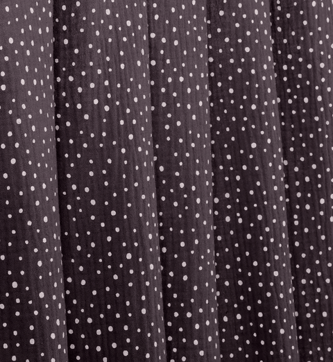 Eine Nahaufnahme von KraftKids Stoff Musselin beige MUW SSS141 zeigt den weichen Stoff aus 100% Baumwolle mit gleichmäßig verteilten kleinen weißen Punkten, zeitlosen Mustern, vertikalen Falten und einer zarten Textur.