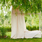 Das KraftKids Bettbaldachin Musselin Kirschen drapiert sich elegant über ein gemütliches weißes Bett und bildet einen charmanten Baldachin, der mit der Natur verschmilzt - perfekt als stilvolles Kinderzimmer-Accessoire.