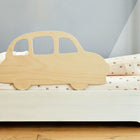 Der KraftKids Rausfallschutz aus Leimholz Auto sorgt als hölzerner Bettschutz in Form eines Autos für Charme und ergänzt perfekt die geblümte Bettwäsche in einem gemütlichen, hellen Kinderzimmer.