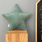 Ein weiches Sternkissen Cord Breitcord Mint von KraftKids sitzt auf einem Holzpodest im Kinderzimmer neben einer Tafel mit weißen Kreidebuchstaben.