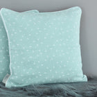 Zwei mintfarbene Kissenbezüge aus Musselin mit weißem Pusteblumen-Muster von KraftKids liegen auf einem weichen, grauen Untergrund - ideal, um deiner Bettwäschekollektion einen Hauch Charme zu verleihen.