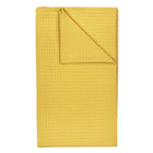 Die KraftKids Babydecke Waffel Piqué in senf ist eine handgefertigte, weiche Baumwoll-Babydecke mit Waffelstruktur, sauber gefaltet mit einer umgeschlagenen Ecke, dargestellt auf weißem Hintergrund - hergestellt in der EU.