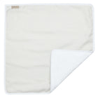 Eine leichte Wickelunterlage Leinen in zartem Grün-Weiß von KraftKids, mit strukturierter weißer Unterseite, weißem Rand und hellbraunem Anhänger - teilweise gefaltet, um beide Seiten zu zeigen. Eine praktische Wickelunterlage Baby für das Wickeln unterwegs.