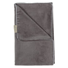 Die gefaltete, graue Babydecke Cord Breitcord von KraftKids hat eine gerippte Struktur, ein sichtbares Etikett an der linken Kante und eine weiße Zierleiste entlang der oberen Naht.